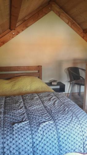 a bedroom with a bed and a chair at Le Chalet de Lili in Névache