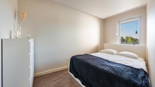 a white bedroom with a bed and a window at Bursztynowe Osiedle Jantar, Sun & Snow in Jantar
