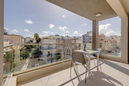 a balcony with a table and a view of a city at Cosy 1BR Apartment in central St Julian's in St Julian's