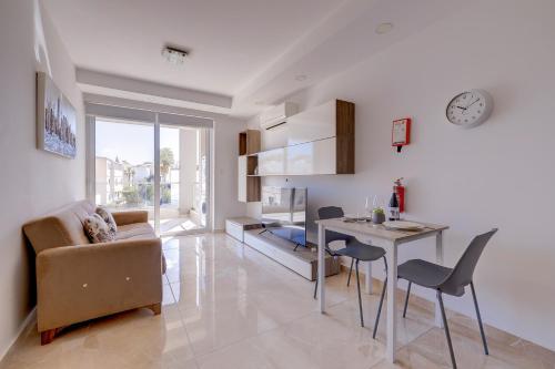 a kitchen and living room with a table and chairs at Cosy 1BR Apartment in central St Julian's in St Julian's
