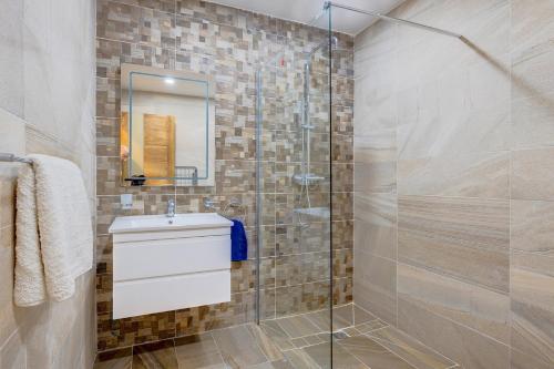 uma casa de banho com uma cabina de duche em vidro com um lavatório e um WC. em Cosy 1BR Apartment in central St Julian's em St. Julian's