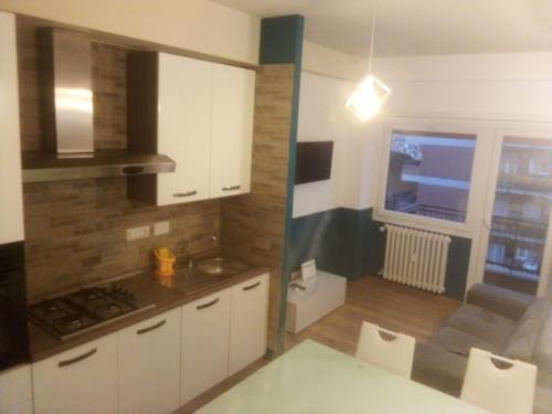 a kitchen with white cabinets and a table and a window at Il Coriandolo 2 in Rome