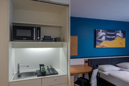a room with a kitchen with a sink and a microwave at Dean's Home Budapest in Budapest