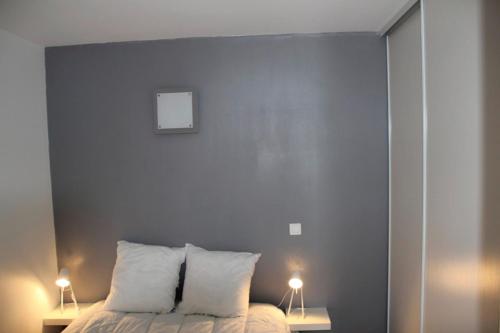 1 dormitorio con 1 cama con 2 luces en 2 mesas en 40m All Comfort In Front Of The Old Port en La Rochelle