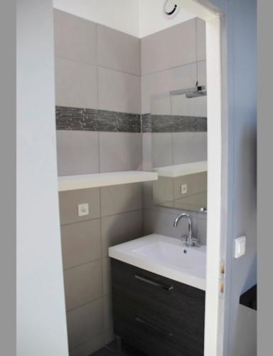 een badkamer met een wastafel en een spiegel bij 40m All Comfort In Front Of The Old Port in La Rochelle