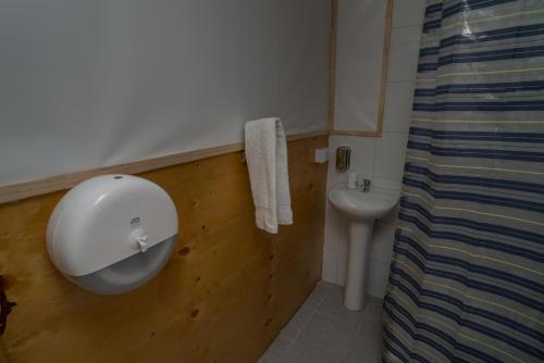 a bathroom with a white sink and a toilet at Cabañas Ensenada Bosque Nativo in Ensenada
