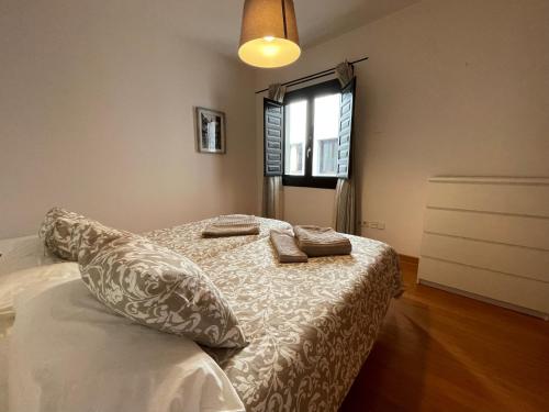 a bedroom with a bed with pillows and a window at Palacio Santa Ursula in Toledo