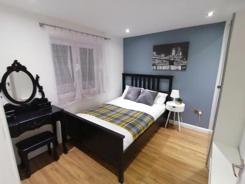 a bedroom with a bed and a vanity and a mirror at Lovely 2-Bed Apartment in Coventry in Coventry