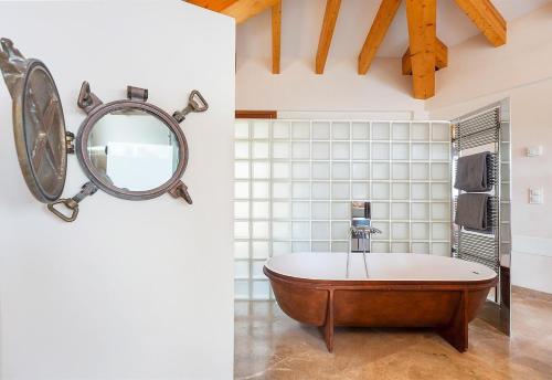 uma casa de banho com uma banheira e um espelho. em Seaside em Capdepera