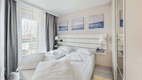 מיטה או מיטות בחדר ב-Apartamenty Sun & Snow Bursztynowa