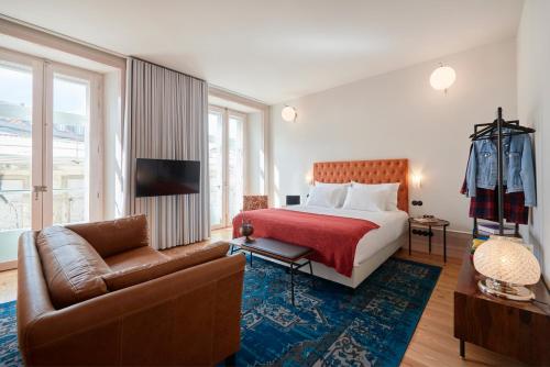 um quarto de hotel com uma cama e um sofá em Cais Urban Lodge em Lisboa