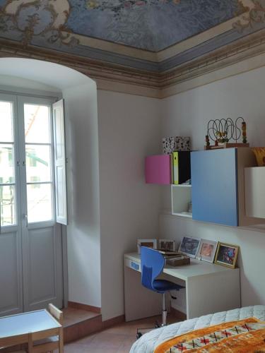 a bedroom with a bed and a desk and a window at La Casa dello Spolvero in LʼAquila