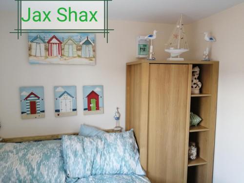 1 dormitorio con un cartel de alex shaw sobre una cama en The Beach Hut Home from Home in Leysdown on Sea en Sheerness