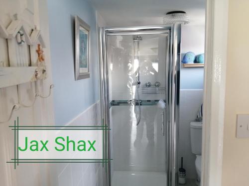 a bathroom with a shower with a glass door at The Beach Hut Home from Home in Leysdown on Sea in Sheerness