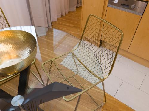 a metal chair sitting next to a glass table at RAFAEL KAISER - Premium Apartments City Centre - Contactless Check-In in Vienna