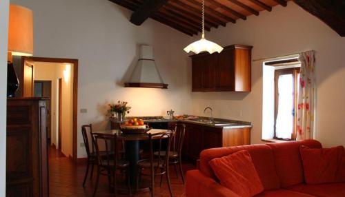 a living room with a couch and a kitchen with a table at Rocca Di Castagnoli in Gaiole in Chianti