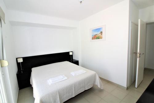 a white bedroom with a bed with white sheets at Historic Centre C - Albufeira in Albufeira