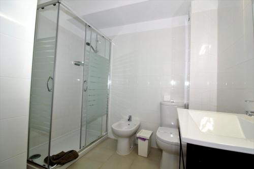 a white bathroom with a toilet and a glass shower at Historic Centre C - Albufeira in Albufeira