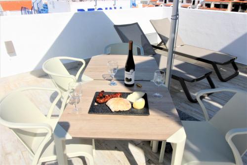 a table with a plate of food and a bottle of wine at Historic Centre B - Albufeira in Albufeira