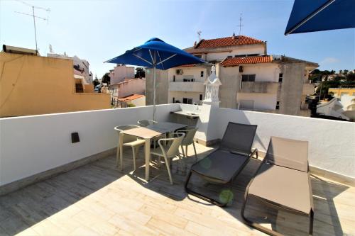 a balcony with a table and chairs and an umbrella at Historic Centre B - Albufeira in Albufeira