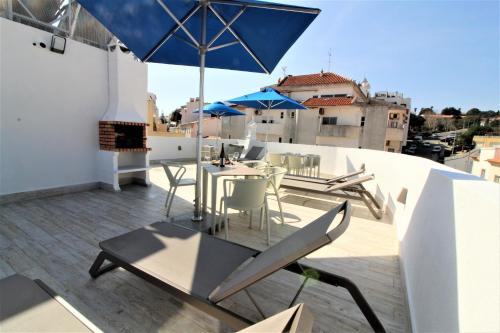 a balcony with a table and chairs and an umbrella at Historic Centre B - Albufeira in Albufeira