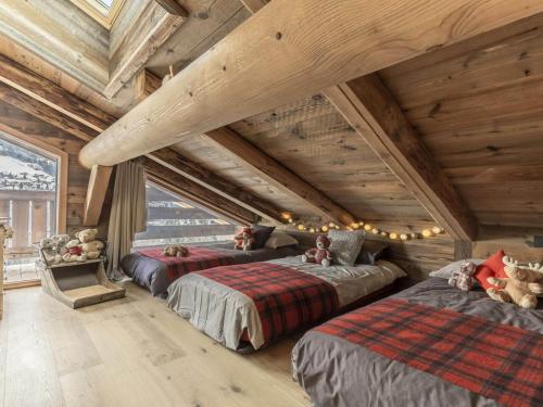 two beds in a room with wooden ceilings at Chalet La Clusaz, 5 pièces, 11 personnes - FR-1-304-229 in La Clusaz