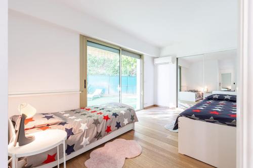 a bedroom with a bed and a large window at Villefranche Sur Mer:Appartement-villa, Vue mer, jardin, parking. in Villefranche-sur-Mer