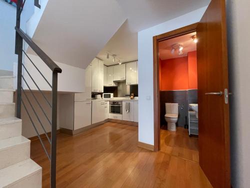 a kitchen with white cabinets and a staircase in a house at Palacio Santa Ursula in Toledo