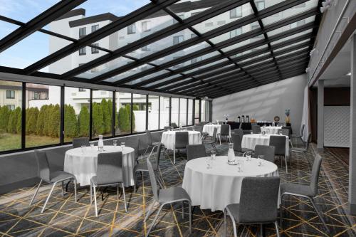 a banquet hall with tables and chairs and windows at Holiday Inn Hasbrouck Heights-Meadowlands by IHG in Hasbrouck Heights