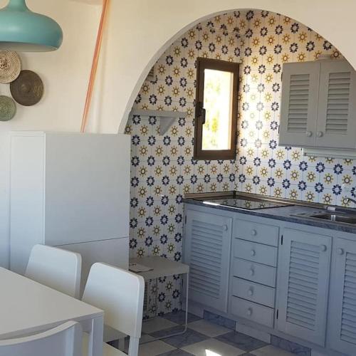 a kitchen with a sink and a mirror on the wall at Formentera Es Pujols 2 camere vicinissimo alla spiaggia in Es Pujols