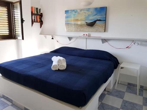 1 dormitorio con 1 cama azul y 2 toallas en Formentera Es Pujols 2 camere vicinissimo alla spiaggia, en Es Pujols