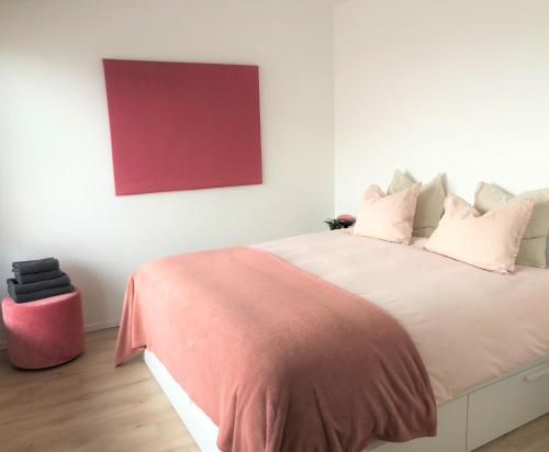 a bedroom with a large bed with a red painting on the wall at Domum in Dilsen-Stokkem