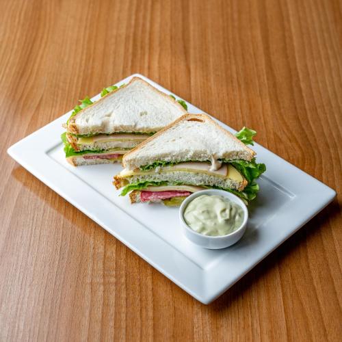 a sandwich cut in half on a plate with sauce at Zago Hotel in Lages