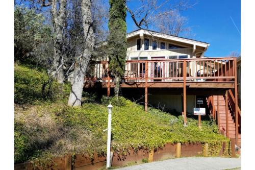 a large house with a deck on a hill at A Bed of Roses in Oakhurst