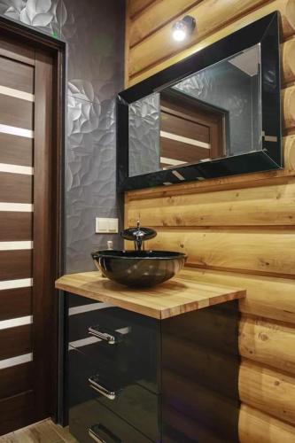 a bathroom with a sink and a mirror at Domek Dream Holiday in Poronin