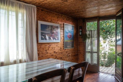 a dining room with a glass table and chairs at Villa Kalaitsidi - plunge pool, gym and unique gardens in Skinés