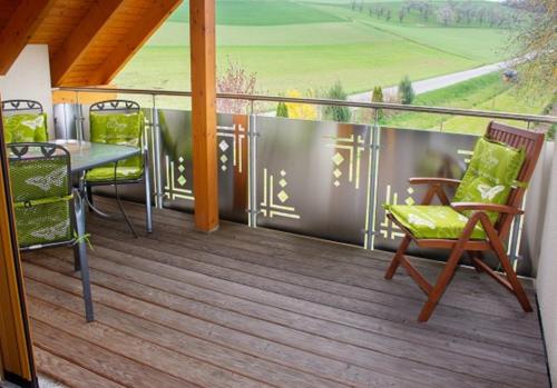 a balcony with chairs and a table and a view at Ferienwohnungen Thoma in Königheim