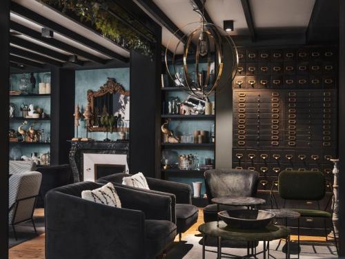a living room with black furniture and a fireplace at Maisons du Monde Hotel & Suites - Nantes in Nantes