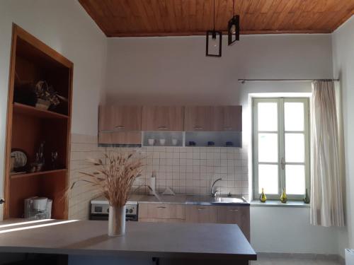 a kitchen with a table and a window at Stone House Kleio Kos in Antimácheia