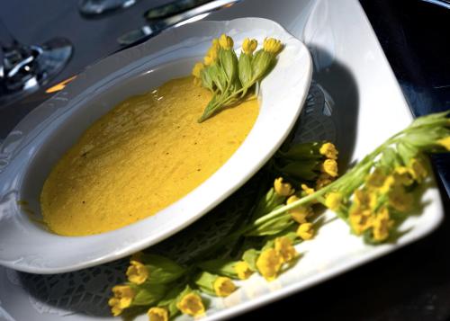 a bowl of soup on a plate with vegetables at Waldhotel Felschbachhof in Ulmet