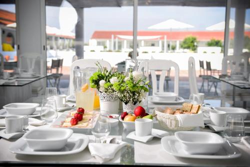 a table with plates and bowls of food on it at Sesmarias Turismo Rural & SPA in Peroguarda