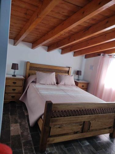 a bedroom with a bed with a wooden frame and wooden ceilings at Di&Ana II - Alojamento Redondo in Redondo