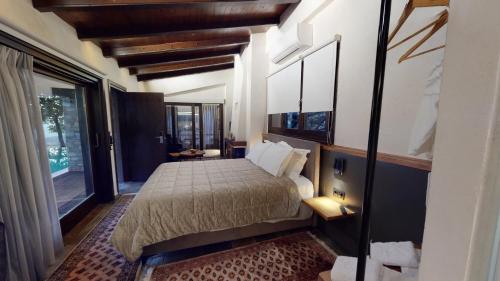 a bedroom with a bed and a large window at Valeni Boutique Hotel & Spa in Portariá
