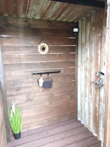 a wooden door to a bathroom with a plant at Bulles d étoiles in Beloeil