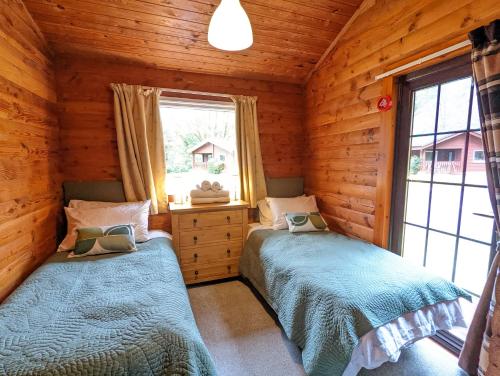 Ένα ή περισσότερα κρεβάτια σε δωμάτιο στο Ruskin Lodges Argyll, by Puck's Glen, Rashfield near Dunoon