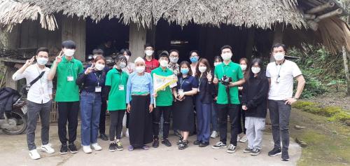 eine Gruppe von Menschen, die vor einer Hütte Masken tragen in der Unterkunft Homestay Nguyễn Huệ in Làng Mõ
