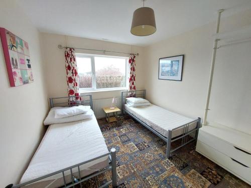 Duas camas num quarto com uma janela em Dainville Lodge em Skegness