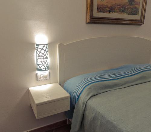 a bedroom with a bed and a lamp and a window at Tenute Efis in Galtellì