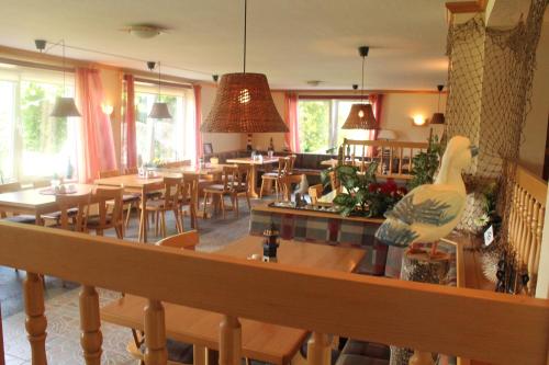 ブレーゲにあるGasthof Breeger-Boddenの木製のテーブルと椅子、窓のあるレストラン