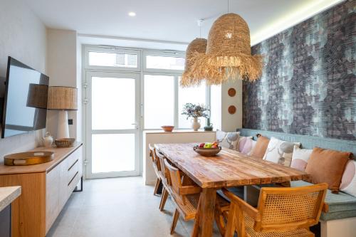 une cuisine et une salle à manger avec une table et des chaises en bois dans l'établissement New Art Gallery Loft in the Heart of Paris 15, à Paris